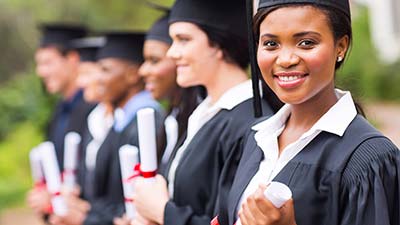 woman wearing a graduation robe and holding a master degree